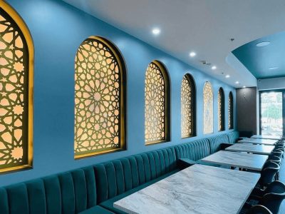 Dining room at Baytouna Restaurant with backlit arched screens and banquette seating