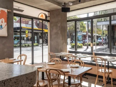 Street-facing dining room with bentwood chairs at Henrietta