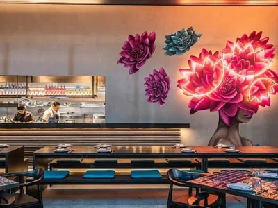 Banquette seating beneath illuminated floral artwork at LILYMU