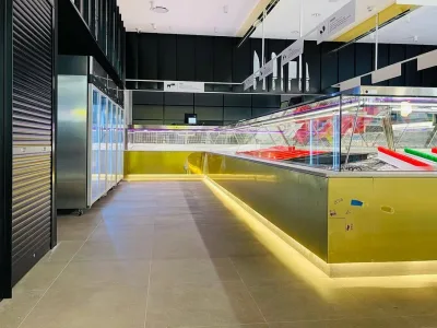 Retail floor at NAK Meats with refrigerated display and upright fridges