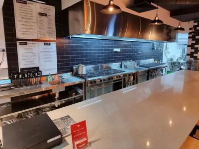 Cooking line beneath a stainless steel extraction canopy at Pasta La Vista